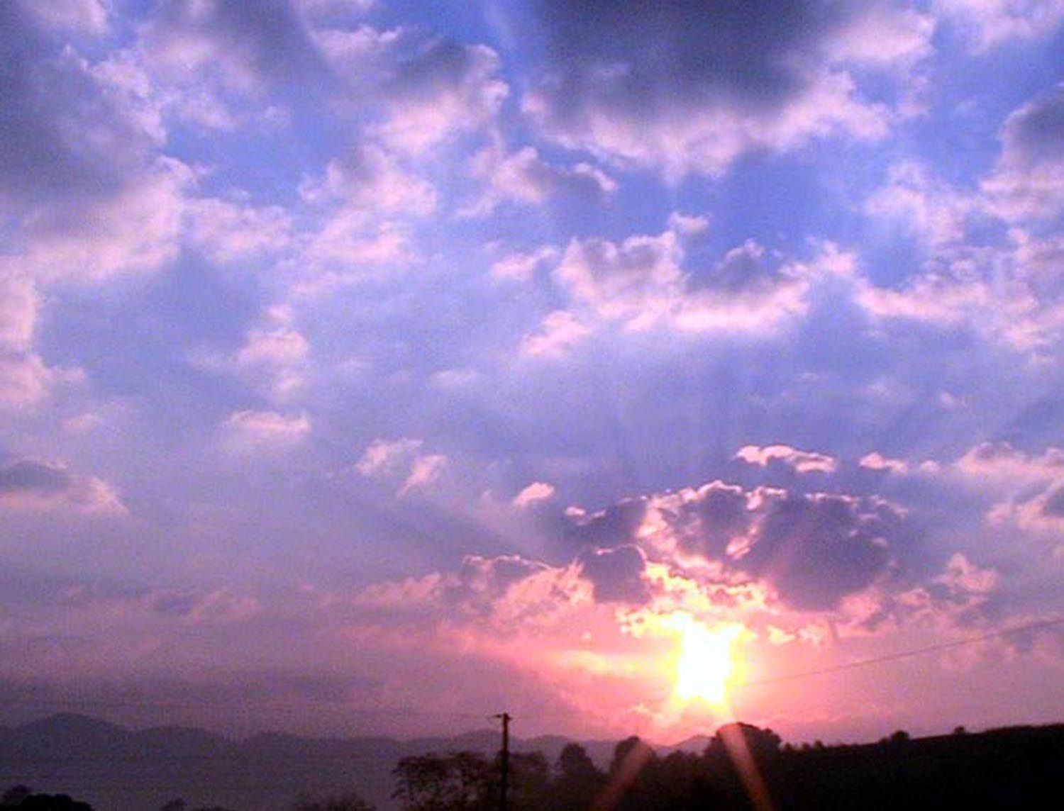 Sunrise over mountain with clouds and rays of light